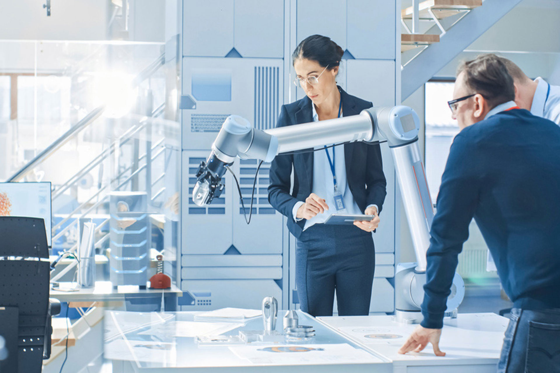 Engineers reviewing a process in front of a collaborative robot
